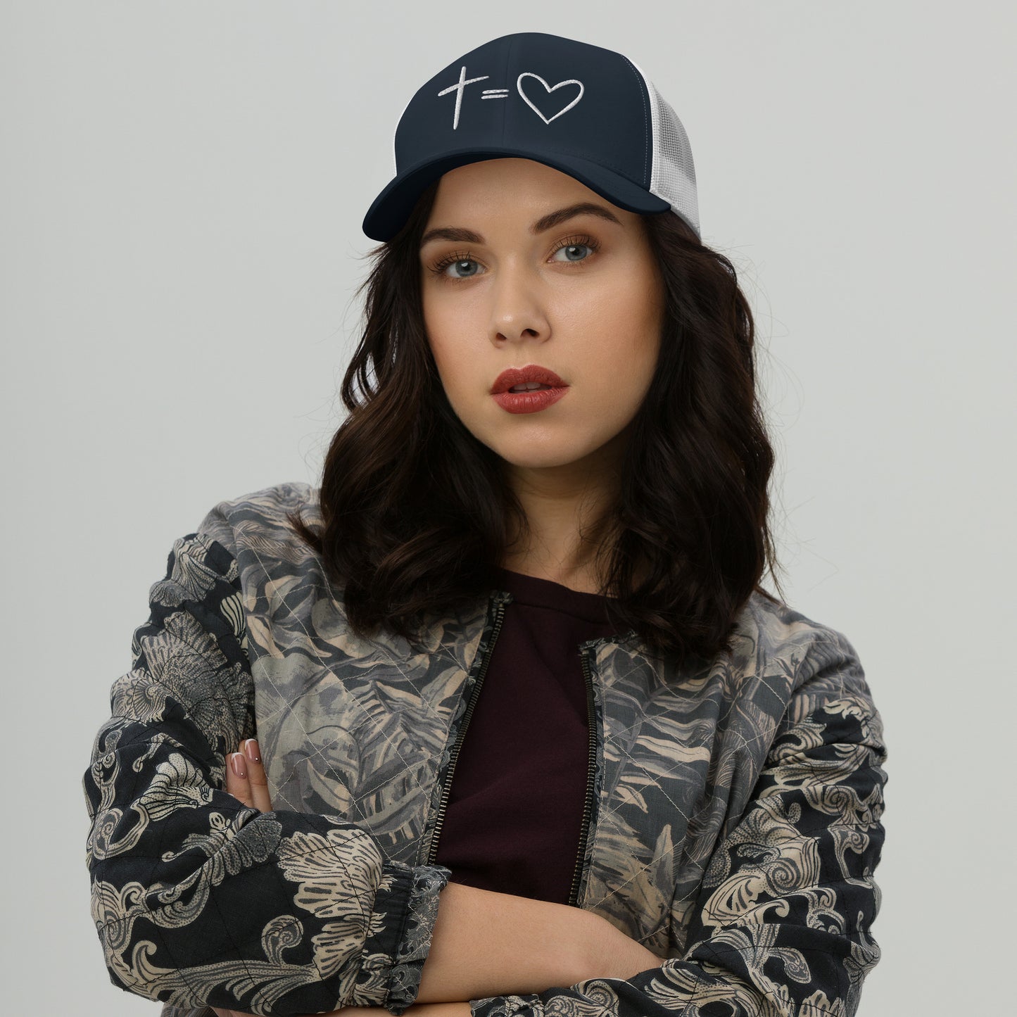 Navy Cross Equals Heart Christian hat on model with arms crossed and neutral expression