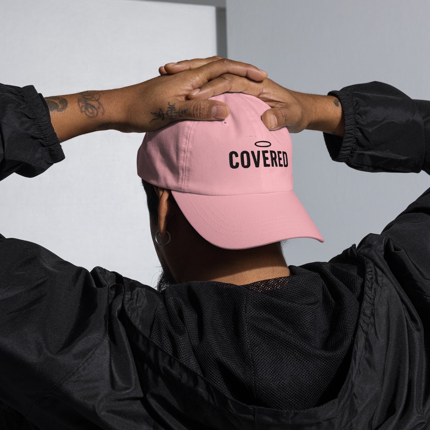 Rear view of pink dad christian hat with halo and COVERED text stitched in black