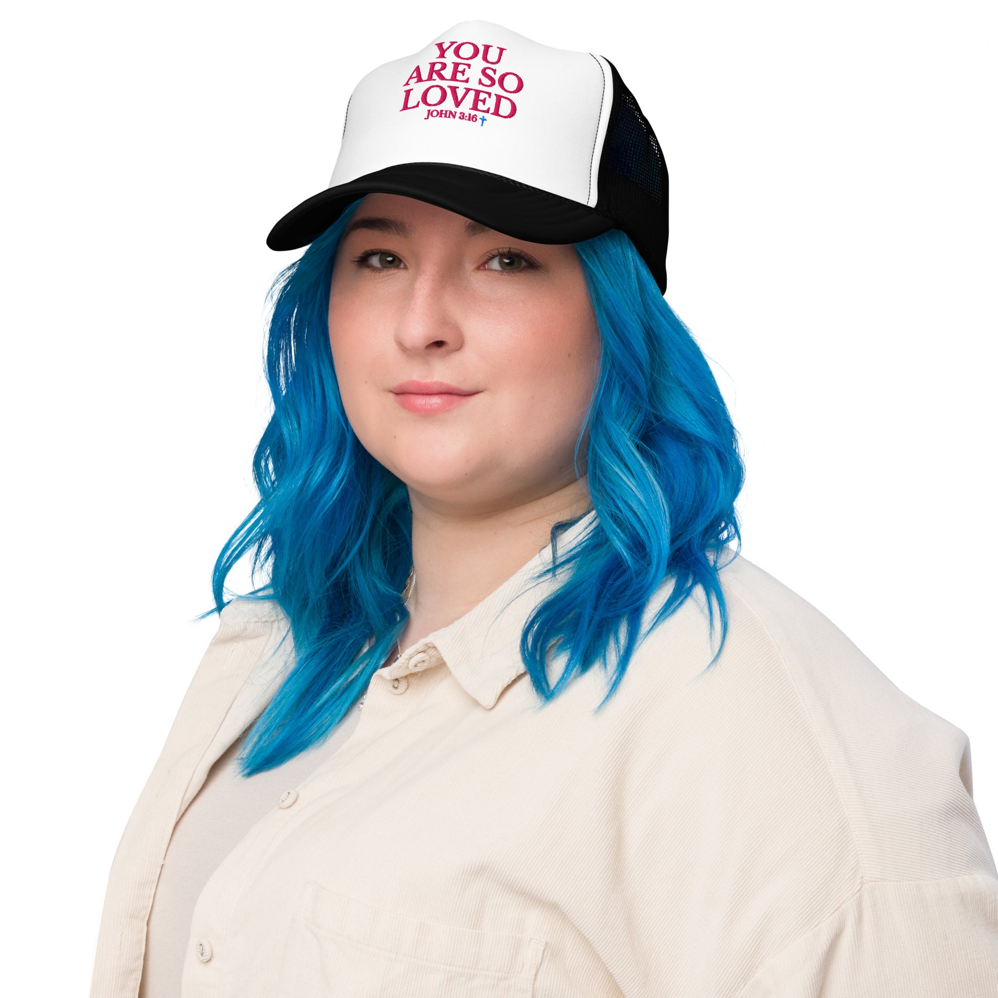Model with blue hair wearing white and black Christian YOU ARE SO LOVED Trucker Hat  with bold pink lettering